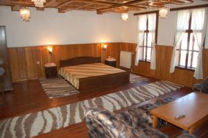 Habitación grande con cama y sofá en Trevnenski Kat Hotel en Tryavna