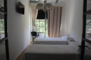 a bedroom with two beds and a window at Lotel Casa Noble in Valencia