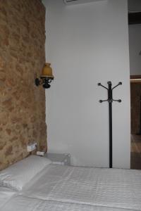a bed with a cross next to a brick wall at Lotel Casa Noble in Valencia +17 photos