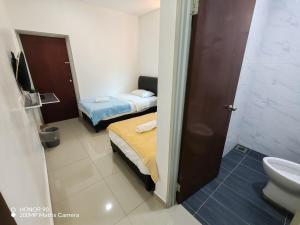 a bathroom with two beds and a toilet and a sink at Arkid 10 Guesthouse in Ipoh +57 photos
