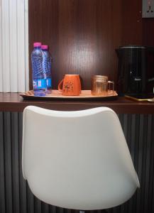 a white chair in front of a counter with bottles of water at Hotel St Flavien Lomé in Taméklo