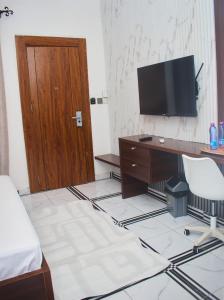 a room with a desk and a television on a wall at Hotel St Flavien Lomé in Taméklo +16 photos