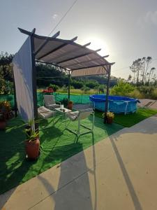 a patio with a table and chairs under a canopy at Casa da Bivó in Figueiró dos Vinhos