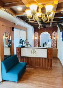 a salon with a blue couch in a room at Hotel Rajwada Nagpur in Nagpur