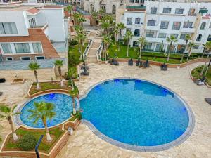 an overhead view of a large swimming pool with palm trees and buildings at Dominium Residence in Agadir