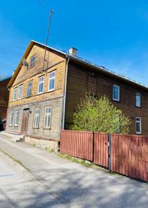 a wooden house with a fence in front of it at City centre one room apartment in Tartu