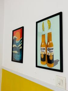 a framed picture of two bottles of beer on a wall at Turtlenest by the Beach in Morjim