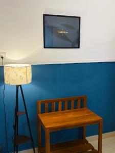a blue wall with a bench and a picture of a plane at Turtlenest by the Beach in Morjim
