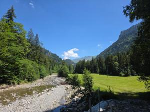 a river in the middle of a field with trees at Gackernästli Emmental in Bärau +31 photos