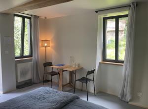 a bedroom with a table and two chairs and a bed at Le Moulin de St André in Saint-André-en-Morvan +36 photos