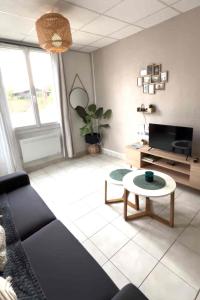 a living room with a couch and a table at Savana Lodge, Wi-Fi, Parking Privé et Calme, Sortie 12 ChanaS in Chanas