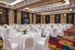a banquet hall with white tables and white chairs at The Trans Luxury Hotel Surabaya in Surabaya +69 photos