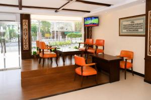 a waiting room with orange chairs and a table at Royalton Hotel Rawalpindi in Rawalpindi