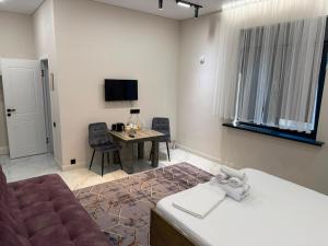 a room with a couch and a table and a television at Sherpa space in Almaty