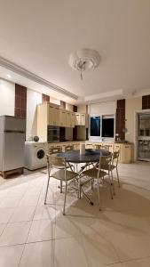 a large kitchen with a table and chairs in it at Villa Korba 1st Floor in Korba