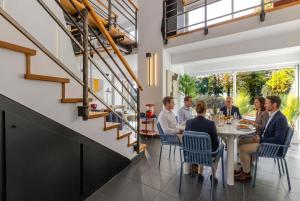 a group of people sitting around a table in a restaurant at Villa de rêve - Climatisation - Sauna - Spa - babyfoot - Arcade in Quatzenheim