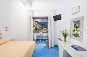 Schlafzimmer mit einem Bett und Stadtblick in der Unterkunft Hotel Vittoria in Positano