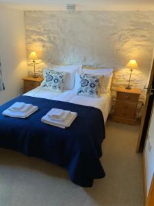 a bedroom with a large bed with towels on it at Tithe Barn 2 - Abercelyn Cottages - Llanycil - Bala - Gwynedd - LL23 7YF - UK in Llanycil