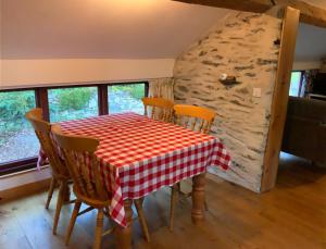a table with chairs and a red and white checkered table cloth at Tithe Barn 2 - Abercelyn Cottages - Llanycil - Bala - Gwynedd - LL23 7YF - UK in Llanycil
