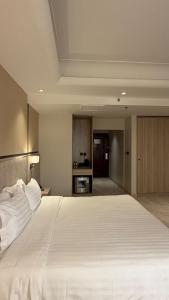 a large white bed in a room with a kitchen at The Business Hotel By Seafront فندق ذا بيزنس in Jeddah +21 photos