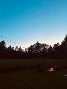 a fire in a field with a tent and a campfire at Zariņmājas Mistērija in Ceļarāji +27 photos