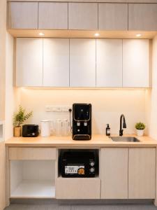 a kitchen counter with a coffee maker and a sink at Commune Lane Guesthouse, George Town in George Town +42 photos