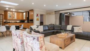 a living room with a couch and a table at Mancave Luxury Homes in Alberton