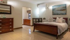 a bedroom with a bed and a dresser and a mirror at Mancave Luxury Homes in Alberton
