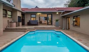 a swimming pool in the backyard of a house at Mancave Luxury Homes in Alberton