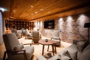 a lobby with chairs and a table and a tv at Das Bayrischzell Familotel Oberbayern in Bayrischzell +189 photos