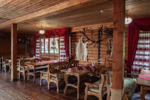 a dining room with wooden tables and chairs at Бойківський двір in Yasenitsa Zamkova