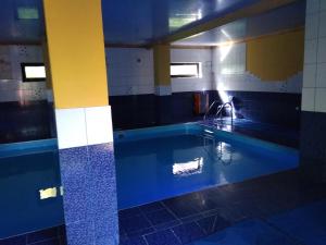 a bathroom with a swimming pool with a sink at Бойківський двір in Yasenitsa Zamkova
