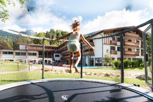 a young girl jumping on a trampoline at Das Bayrischzell Familotel Oberbayern in Bayrischzell