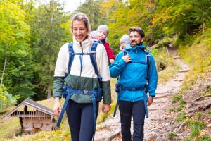 a family walking down a trail on a forest trail at Das Bayrischzell Familotel Oberbayern in Bayrischzell