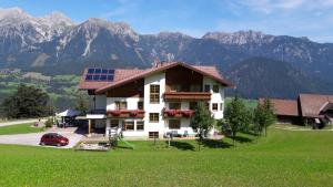 a house with solar panels on it in front of mountains at Hotel-Pension Asingerhof in Schladming