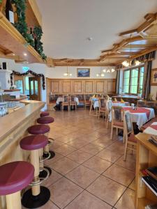 a restaurant with tables and chairs and a bar at Hotel-Pension Asingerhof in Schladming +10 photos