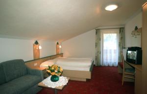 a hotel room with a bed and a couch at Grossarzbachhof in Lutago