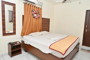 a bedroom with a bed with a wooden headboard at Hotel Siddveer Grand in Guntūr