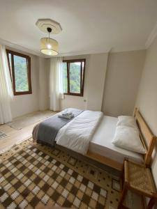 a bedroom with a large bed and two windows at Komilo Homes - Functional Modern Suite in Çamlıhemşin