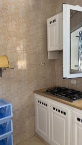 a kitchen with white cabinets and a stove top oven at Villa Korba 2nd Floor in Korba