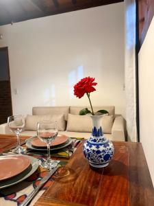 a red flower in a blue and white vase on a table at Mini Casa-Aconchego e Fitness in Pirenópolis