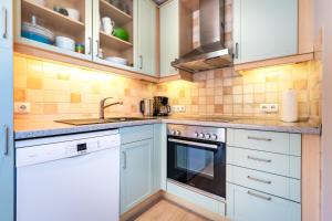 a kitchen with white cabinets and a sink at Ülleken in Fehmarn