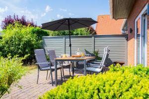 a table and chairs with an umbrella on a patio at Ülleken in Fehmarn