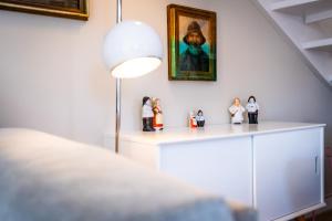 a room with figurines on a shelf with a painting at Ülleken in Fehmarn