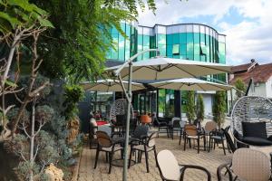 an outdoor patio with chairs and tables and umbrellas at Hotel Impex in Peje