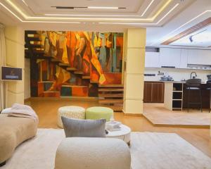 a living room with a large painting on the wall at Capediem luxury apartment in Oba Ile