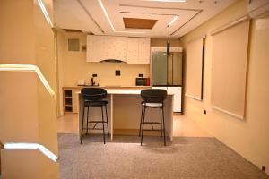 a kitchen with two stools at a kitchen counter at Capediem luxury apartment in Oba Ile +19 photos