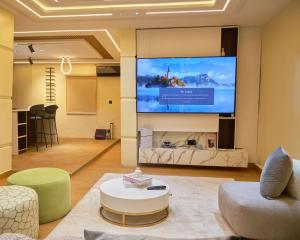 a living room with a large screen on the wall at Capediem luxury apartment in Oba Ile