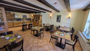a restaurant with wooden tables and chairs and a kitchen at Maria Aurora in Quedlinburg