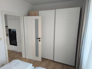 a bedroom with a white closet and a door at Dubrowes cottage in Bobrów